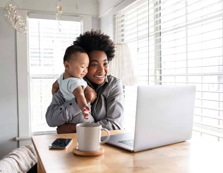 Online Business Secrets For Stay At Home Mums like this mother working while carrying her baby at home